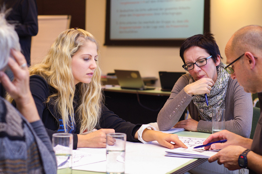 Personen in einem Gespräch analysieren gemeinsam Unterlagen