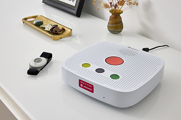 Hausnotrufgerät und Armband auf einer Kommode