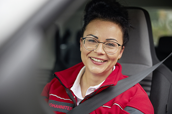 Pflegefachkraft sitzt im Auto