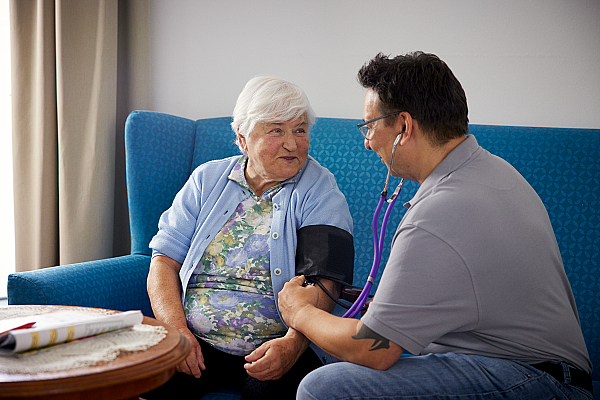 Pflegekraft misst den Blutdruck der Patientin