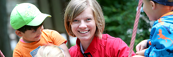 Kinder schaukeln gemeinsam mit einer Erzieherin.
