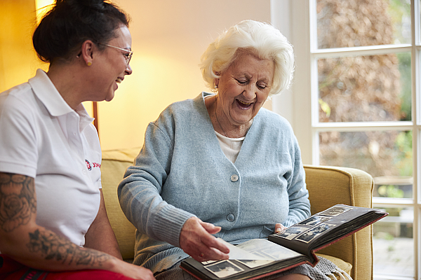 Ambulanter Pflegedienst im Einsatz: Gemeinsames durchschauen von Bildern mit einer Klientin