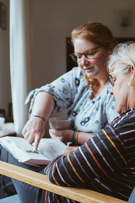 Eine Johanniter-Pflegefachkraft unterhält sich mit einer Kundin.