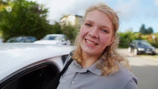 Mitarbeiterin der Johanniter an einem Auto.