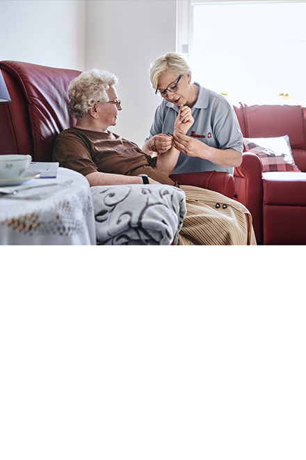 Senioren und soziale Dienste: Pflegedienst misst Blutdruck bei Seniorin