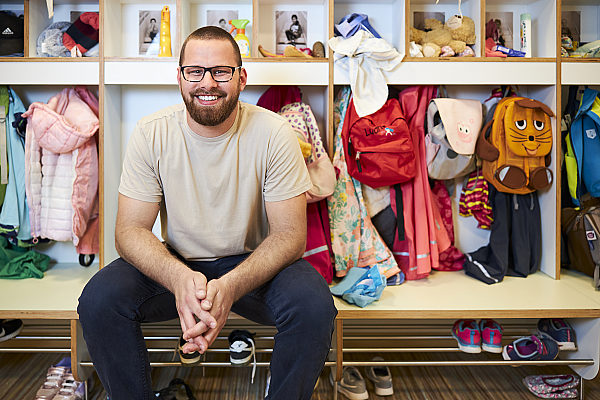 Eine Integrationshilfe sitzt an der Garderobe einer Grundschule