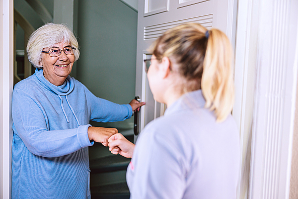 Eine Johanniter-Mitarbeiterin interagiert mit einer älteren Frau.