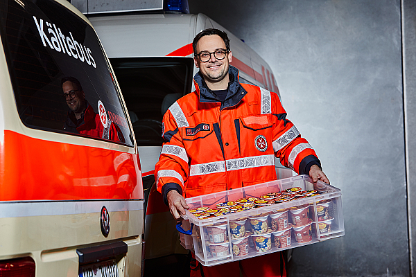 Ein Helfer des Kältebus trägt Lebensmittel aus dem Einsatzwagen