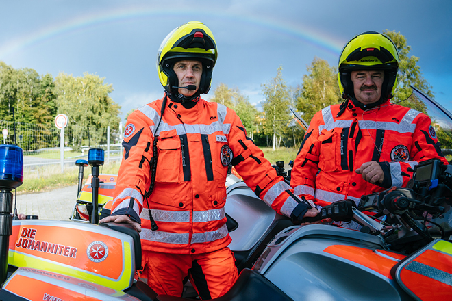 Zwei Einsatzkräfte stehen neben ihren Motorrädern auf der Straße