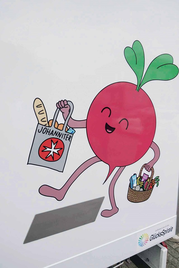 Das Maskottchen der Lebensmittelausgabe prangt auf der Außenseite des Kühltransporters und bringt Lebensmittel.