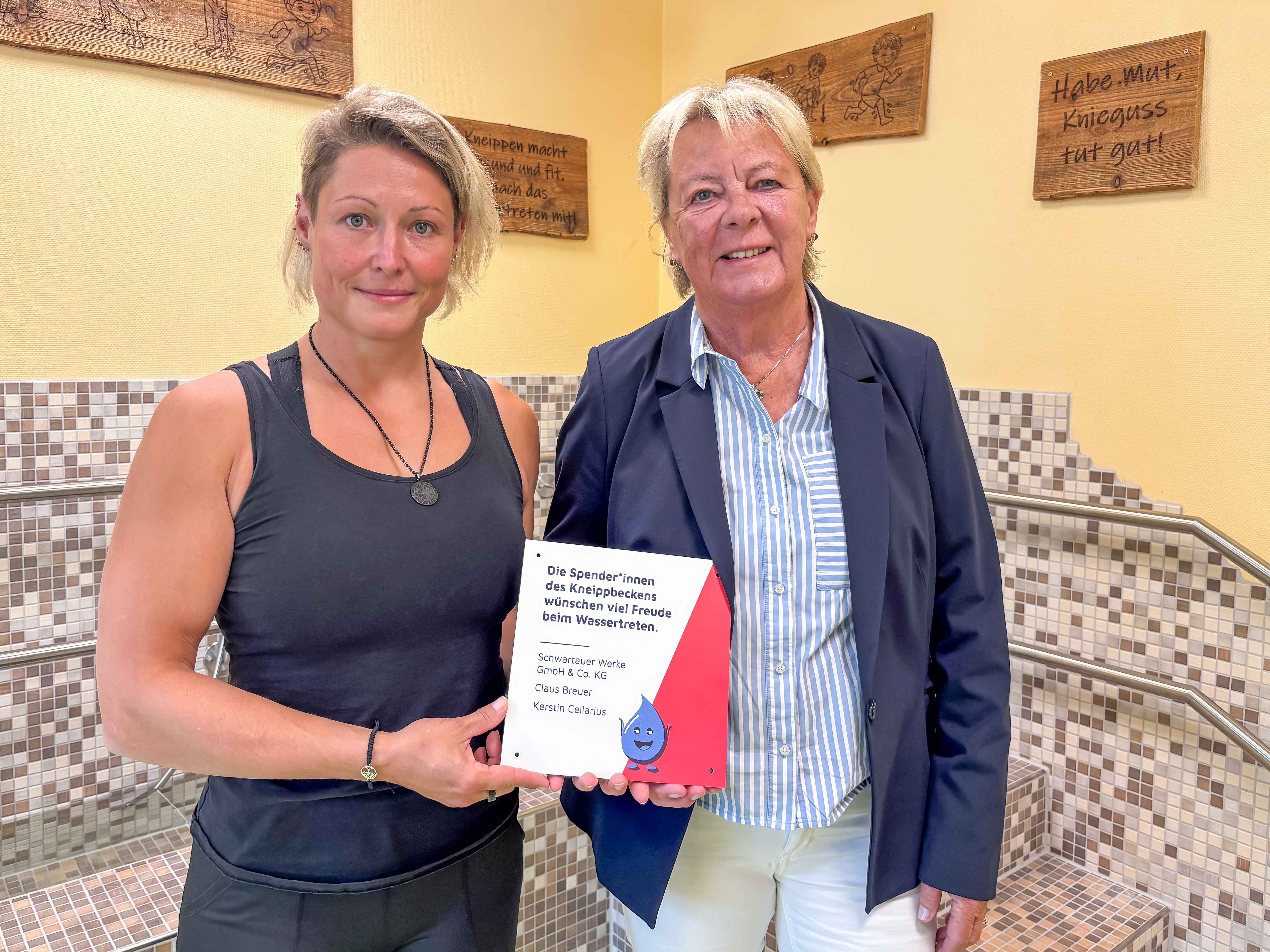 ita-Leiterin Tina Pötzl und Kerstin Cellarius halten ein Spendenschild hoch.