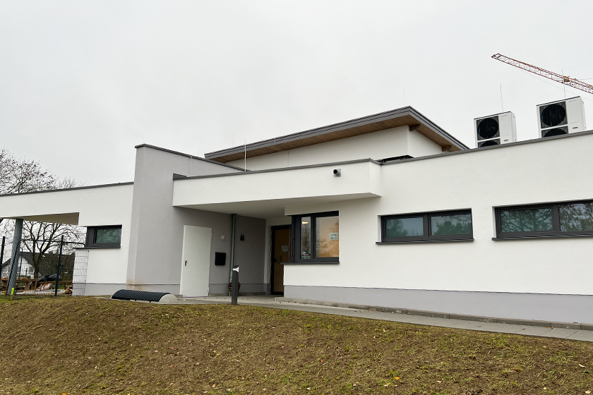 Weißes Gebäude mit grauen Fensterelementen, der Johanniter-Kindertageseinrichtung "Die wilden Strolche"u