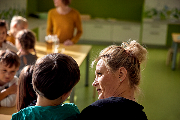 Eine Erzieherin spricht in der Kita mit einem Jungen.