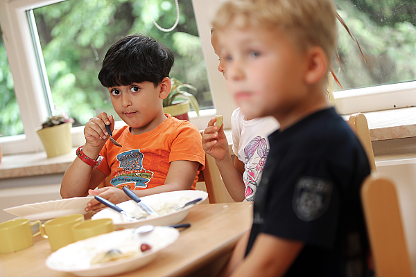 Drei Kinder beim gemeinsamen Essen.