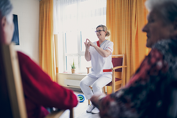 Eine blonde Frau erklärt den Anwesenden etwas in der Sportstunde