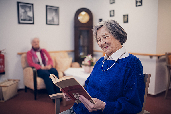 Eine Bewohnerin in blauem Pullover liest