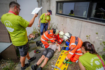 Rettungskräfte stabilisieren Verletzten, Einsatzleitung dokumentiert Situation