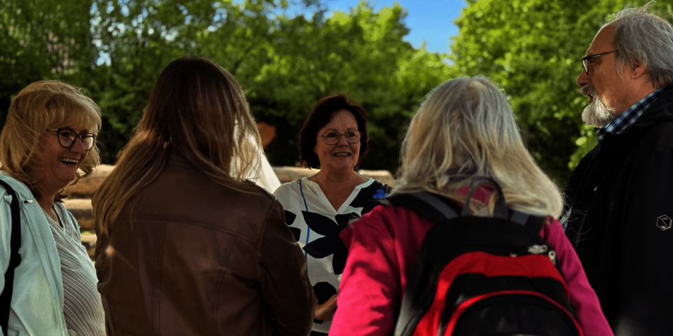 mehrere Personen sprechen im Außengelände der Kita miteinander