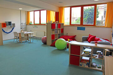 Gemütliche Kissen, Bücher und Spiele stehen für die Kinder bereit. 
