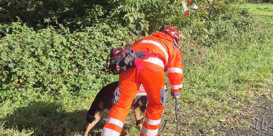 Eine Johanniterin gibt ihrem Hund Anweisungen
