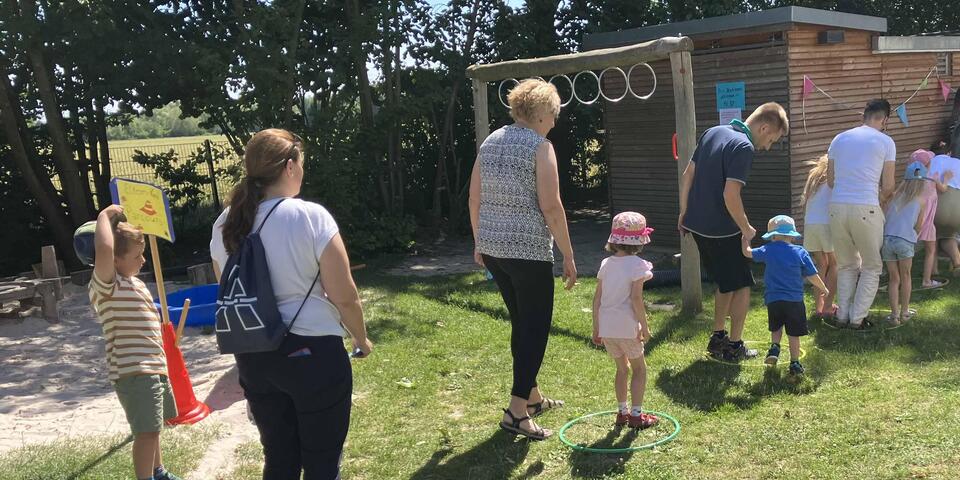 Eltern und Kinder stehen in einer Schlange