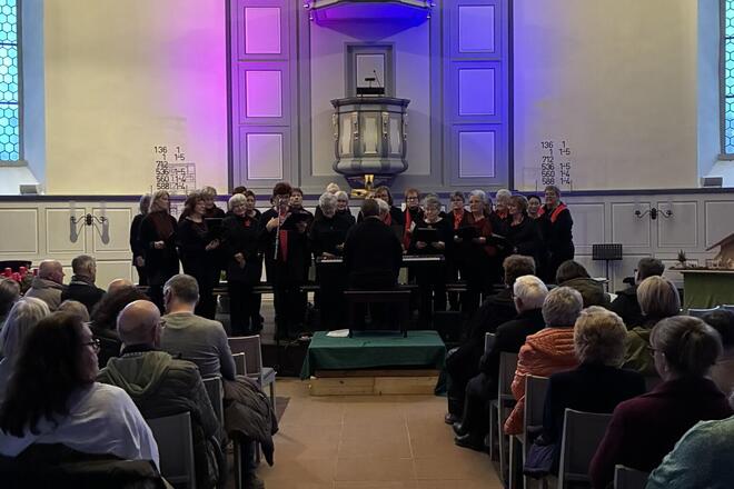Der Frauenchor singt zwischen voll besetzten Bänken in der festlich beleuchteten Kirche
