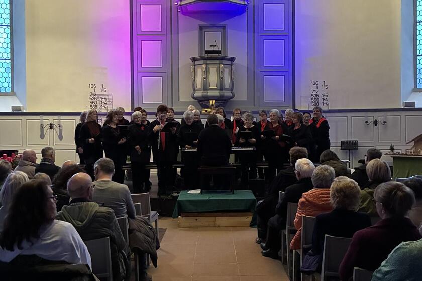 Der Frauenchor singt zwischen voll besetzten Bänken in der festlich beleuchteten Kirche