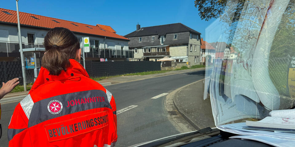 Eine Johanniterin schaut auf eine Straße