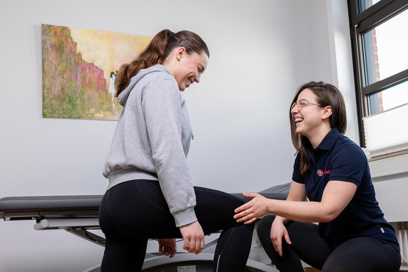 Eine Johanniterin zeigt einem Patienten Übungen der Krankengymnastik.