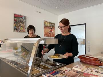 Zwei ehrenamtliche Mitarbeitende an der Essensausgabe.