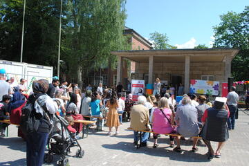 Publikum sitzt vor der Bühne und schaut einem Auftritt zu.
