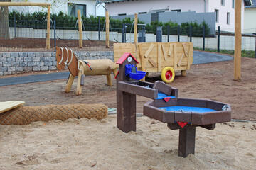 Spielpferd aus Holz und Wasserspielanlage der Kita am Wieter. 