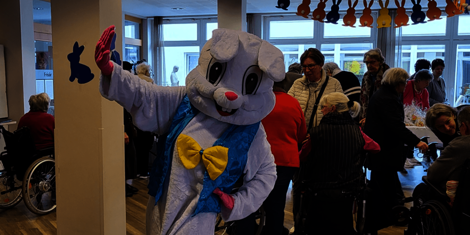 Ein Person winkt im Hasenkostüm