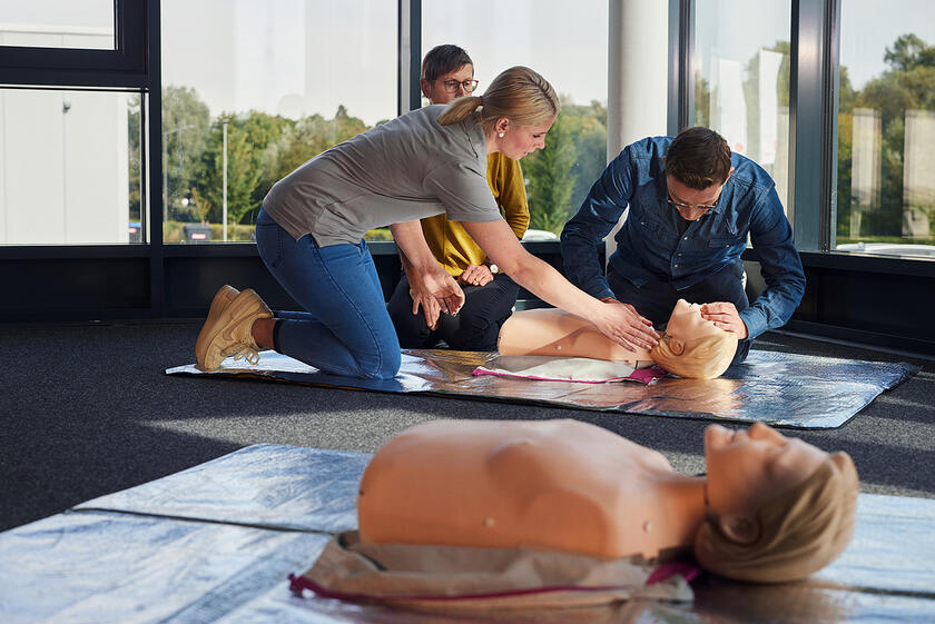 Übung zur stabilen Seitenlage im Erste-Hilfe-Unterricht mit Zuschauern.