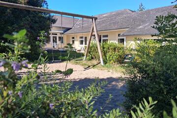 Außenansicht der Kita "Wichtelstube" mit Spielplatz