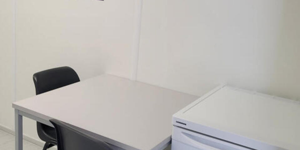 Ausstattung des Johanniter-Handwerkerdorf in Dernau: Aufnahme: Tisch mit kleinem Kühlschrank im Schlafzimmer