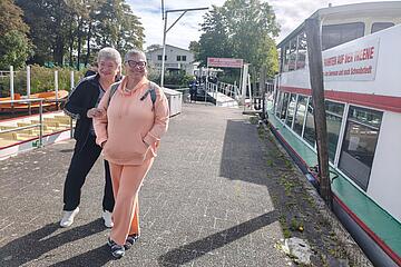 Zwei Personen neben dem Ausflugsboot