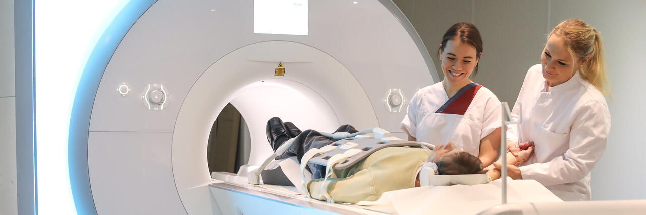 Eine Ärztin und ein Schwester bei einem Patienten im CT