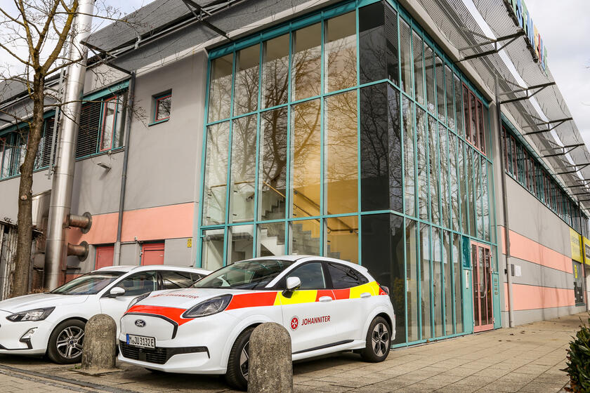 Johanniter-Einsatzfahrzeug vor Gebäude im Aicherpark in Rosenheim.
