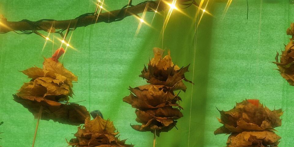 Die Kita-Kinder haben viele verschiedene bunte Blätterfeen gebastelt und an einem Stock mit langen Schnüren aufgehängt.