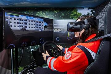 Ein Rettungssanitäter übt im Hubschrauber-Simulator mit VR-Brille eine Notsituation.