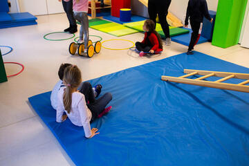 Kinder turnen gemeinsam auf einer Sportmatte