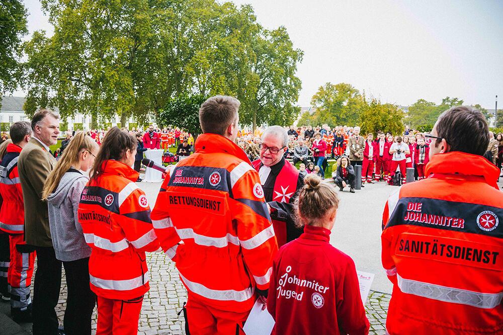 Beim Bundeswettkampf der Johanniter 2017 in Koblenz verleiht Pfarrer Andreas Mann Urkunden an die Mannschaften.