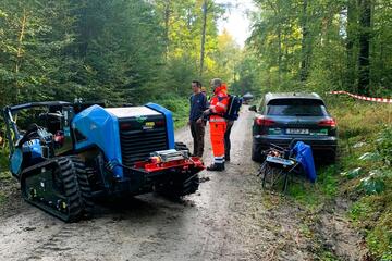 Arbeitsmaschine und Sanitäter im Wald