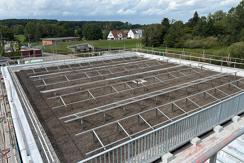 Blick auf ein Flachdach mit den Aluminiumträgern zur Montage von Photovoltaikplatten.