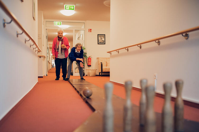 Zwei Bewohnerinnen kegeln auf dem Flur des Johanniter-Stifts