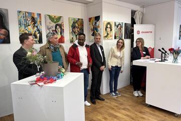 Einige Mitarbeitende und Unterstützende in einer Reihe vor Kunstwerken