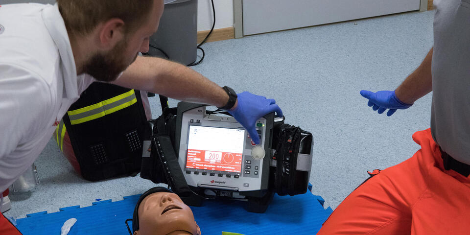 Zwei Johanniter mit Simulationspuppe demonstrieren ihre Wiedebelebungsfähigkeiten.