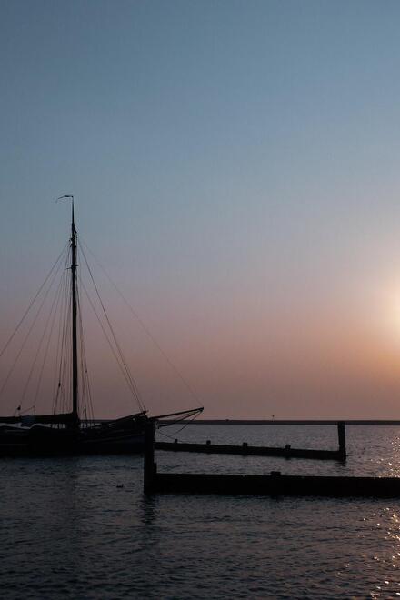 Ein Segelboot am Hafen zum Sonnenuntergang