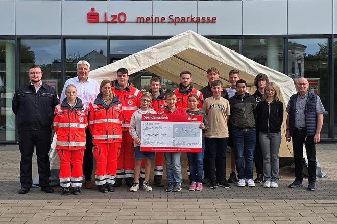 Eine Gruppe Menschen mit großem Scheck.